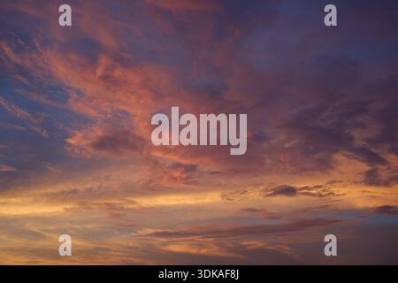 The twilight sky after sunset, its reddish glow burning the sky. A beautiful yet eerie abstract background. Stock Photo