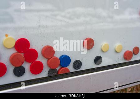 Close up of colorful round magnets attached to a metal surface creating an abstract composition symbolizing organization planning and creativity Stock Photo