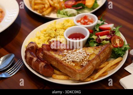 Hearty breakfast plate with toast, scrambled eggs and sausages Stock Photo