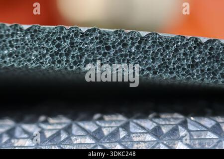 Close up macro of black foam sleeping pad texture. Detail of insulation material for camping mat, showing porous structure for comfort and warmth Stock Photo