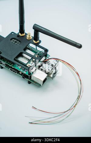 Close-up of an embedded electronics prototype with antennas, connectors, and wiring harness isolated on a light background Stock Photo