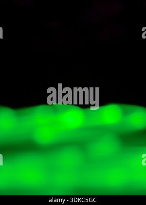 Green light trails creating a dynamic, blurred abstract background, offering a vibrant, flowing visual effect for digital, futuristic, or energy-relat Stock Photo