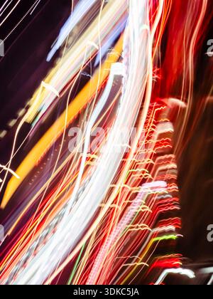 Abstract colorful light trails moving fast through the dark urban street, generating blur streaks and dynamic patterns, symbolizing speed and the ener Stock Photo