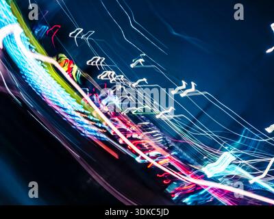 Abstract colorful light trails paint a dynamic blur across the dark blue canvas, evoking concepts of speed, urban energy, and technological connection Stock Photo