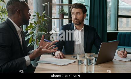 Two multinational business men team businessmen discussing marketing financial strategy brainstorm teamwork development looking laptop worried with Stock Photo