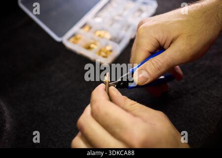Precision tools used for assembling small electronic parts carefully. Focused hands skillfully repairing miniature electronic devices with specialized Stock Photo