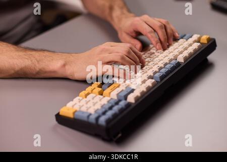 Keyboard typing focus. Closeup of fingers pressing keys with vintage style switches. Studio shot of hobbyist programmer focused on mechanical keyboard Stock Photo
