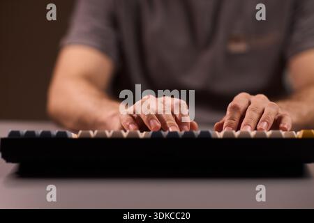 Keyboard typing focus. Closeup of fingers pressing keys with vintage style switches. Studio shot of hobbyist programmer focused on mechanical keyboard Stock Photo