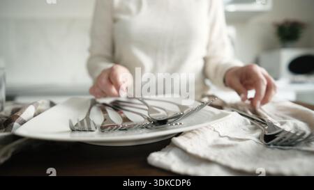 Clean Dishes And Forks Lying On The Table In The Kitchen Stock Photo
