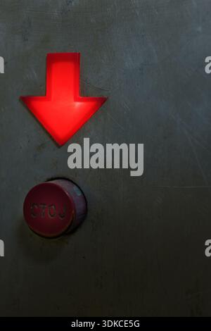 Plastic red down arrow and stop button in Cyrillic, details of an old elevator. Stock Photo