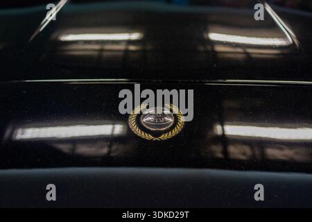 Black Sports Car Hood Emblem CloseUp Capturing Moody Reflections And Polished Chrome In Garage Ambient Light Warsaw, Poland 29-01-2026 Stock Photo