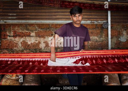 A man is preparing saree for fencing. Maniabandha village, Odisha, India Stock Photo