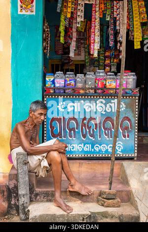 Elderly man resting in front of his shop, Odisha, India Stock Photo