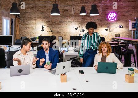 Multi ethnic team collaborating on project in modern office Stock Photo