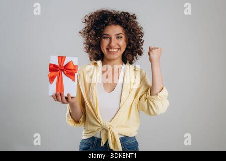 Holidays or birthday conception with gift box. Beautiful woman is in the studio. Stock Photo
