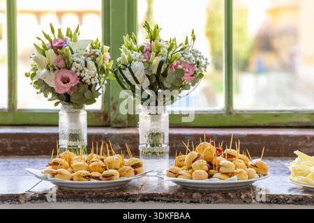 Appetizers and flowers decorating a table for a celebration Stock Photo