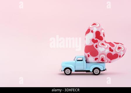 Toy car carrying a heart cushion Stock Photo