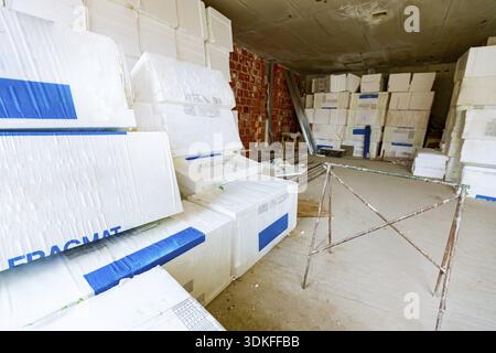 Packages of thermal insulation material, Styrofoam, wrapped in foil waiting to be installed on the walls, placed in the warehouse Stock Photo