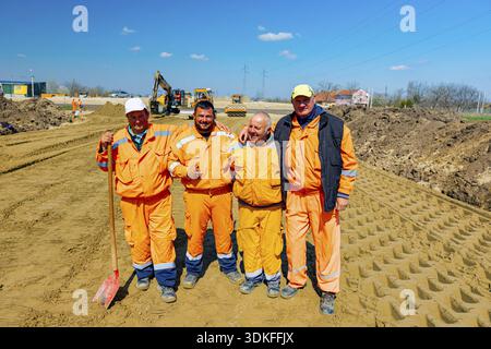 Zrenjanin, Vojvodina, Serbia - April 05, 2021: Construction smiling workers are posing, resting and enjoying at construction site Stock Photo