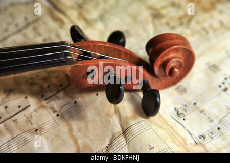 1937 old violin on the background of notes Stock Photo