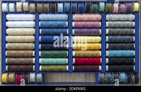 Colored sewing threads on spools arranged in a box Stock Photo