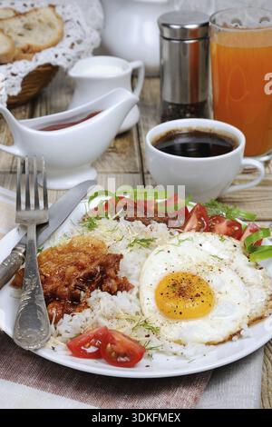 Food, Breakfast - Soft boiled rice with scrambled eggs, bacon, tomato slices and greens Stock Photo