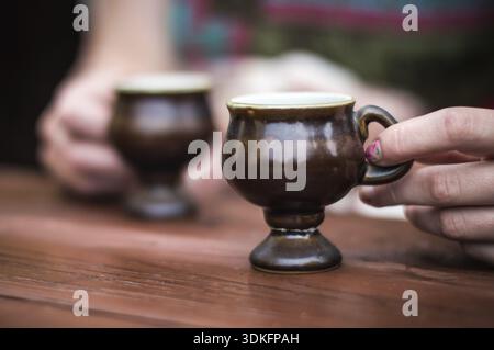 Hands holding coffee cup over dark table Stock Photo