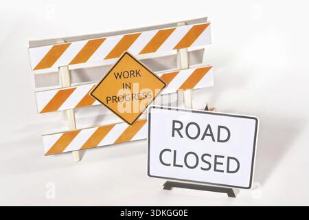 Construction warning barriers with Work in Progress and Road Closed signs over white background Stock Photo