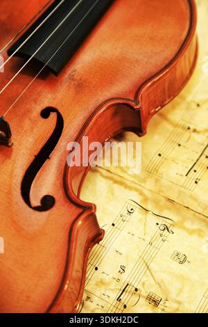 1937 old violin on the background of notes Stock Photo