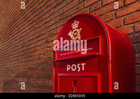 A red danish postbox on a brick wall in the evening sun. Text, The letters must not contain money, Frederikssund, Denmark, 30 mars, 2018 Stock Photo