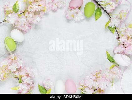 Beautiful delicate Easter composition with pink cherry flowers and multicolored Easter eggs Stock Photo