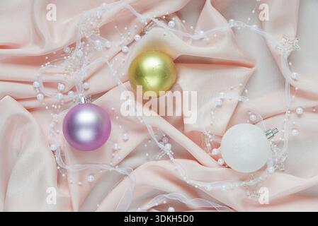 Beautiful Christmas composition with Christmas balls on a pink folded silk. Flat lay composition for greeting cards, websites, social media, magazines Stock Photo