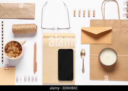Composition with mobile phone, packaging items and delivery paper bag on white background Stock Photo