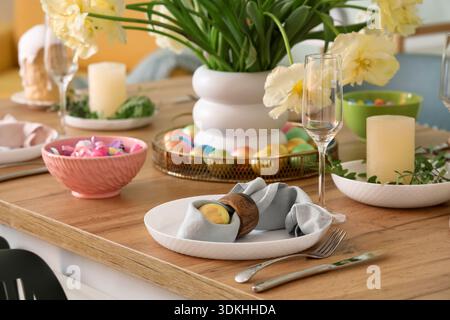 Easter table setting with painted eggs, Easter cake and flowers Stock Photo