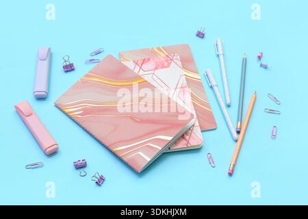 Composition with notebooks and different stationery on color background Stock Photo