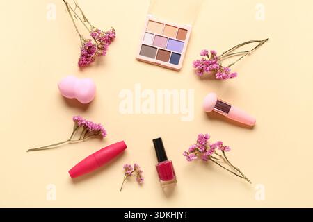 Frame made of makeup products and beautiful gypsophila flowers on beige background Stock Photo