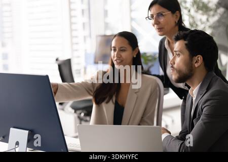 Three diverse teammates working on joint project in modern coworking Stock Photo