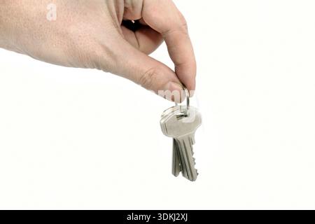 Man holding keys in his hand on white background Stock Photo