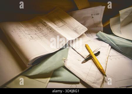 Used mason's graphite square wooden construction pencil and chemical roll pen, are crossed over bunch of architectural blueprints, plans, drawings Stock Photo