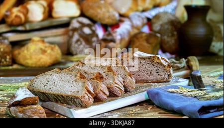 Baker Preparing Handcut Bread Samples, Closeup Of Handcrafted Rye Bread Slices On Wooden Board Stock Photo