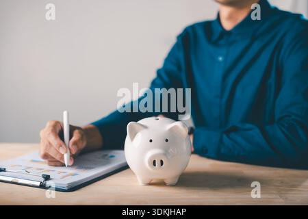 piggy bank finance money documents save management check document, person writing on paper chart, tracking expenses, organizing financial plan, prepar Stock Photo