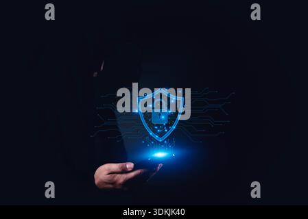 Cybersecurity visualization with hand holding smartphone and glowing shield lock, concept of mobile security, data privacy, protection, and safe digit Stock Photo
