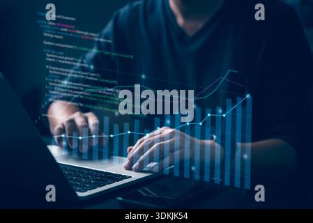 Business analyst using laptop with financial graphs and code overlay, concept of data analytics, fintech, stock market growth, big data, and digital b Stock Photo