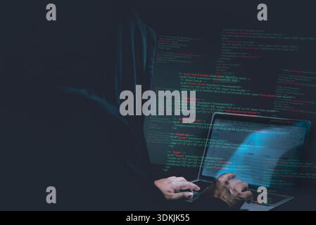 Cybersecurity hacker typing code on laptop in dark room, concept of hacking, malware, identity theft, cyber attack, data protection, and online fraud Stock Photo