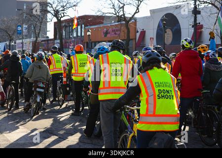 Cyclists wearing high-visibility vests that say "Peaceful Observer Don't Shoot" during Alex Pretti Memorial Bike Ride near Nicollet Ave and 26th St Stock Photo