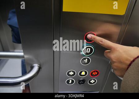 Finger pressing elevator button in building hallway Stock Photo
