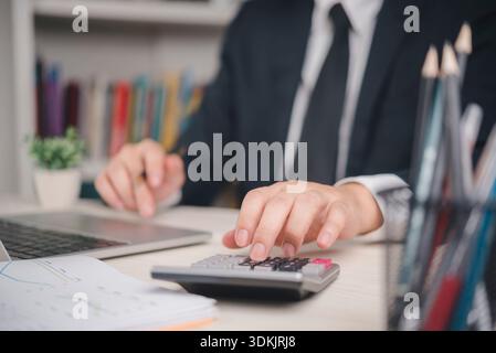 Accountant or financial analyst calculating data calculator in office. Professional working on business audit, company budget, and profit analysis wit Stock Photo