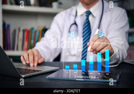 HIPAA, compliance Doctor uses tablet and laptop patient data security and privacy in EHR, charting audit, governance, and encryption progress toward 1 Stock Photo
