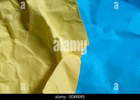 Bright yellow and deep blue paper create a lively, textured composition that inspires joy. Stock Photo