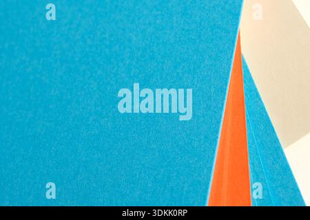 Vibrant blue and orange papers invite artistic expression in a cozy studio. Stock Photo